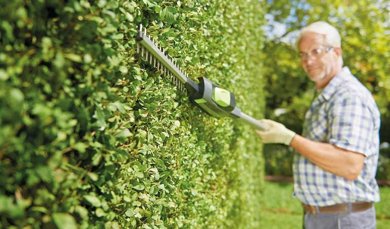 A Old man using Gtech Hedge Trimmer